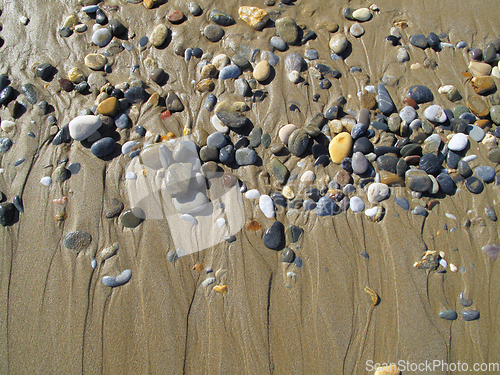 Image of Wet sea pebbles on the sand