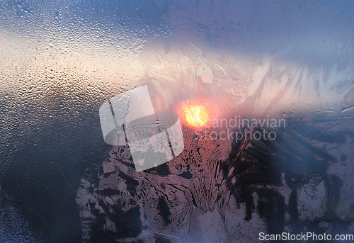 Image of Ice pattern and water drops on glass on a sunny winter morning