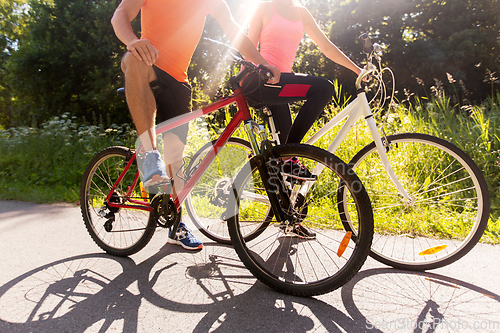 Image of young couple riding bicycles outdoors