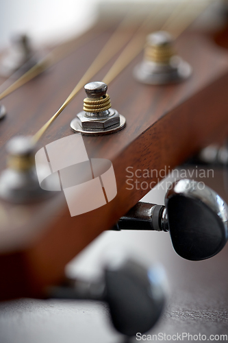 Image of close up of acoustic guitar head with pegs