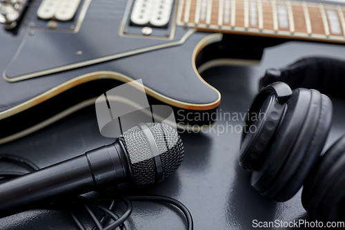 Image of close up of bass guitar, microphone and headphones