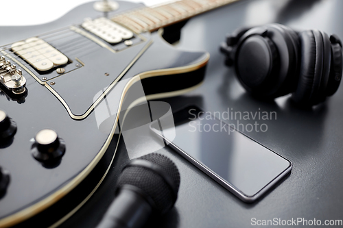 Image of close up of bass guitar and smartphone