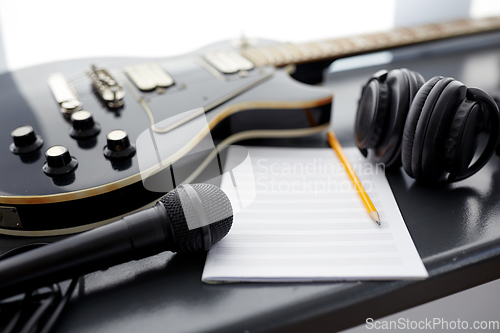 Image of close up of guitar, music book and headphones