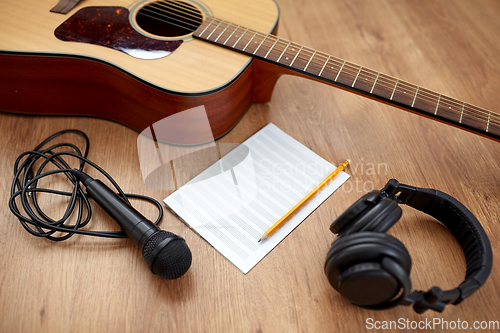 Image of guitar, music book, microphone and headphones