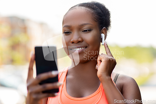 Image of african american woman with earphones and phone