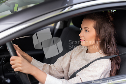 Image of woman or female driver driving car in city