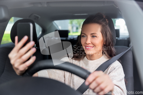 Image of woman or driver driving car and taking selfie