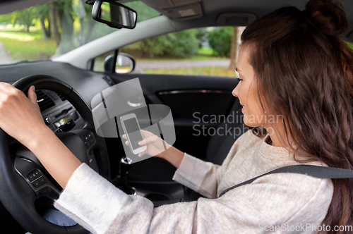 Image of smiling woman or female driver driving car in city