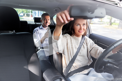 Image of female driver driving car with male passenger