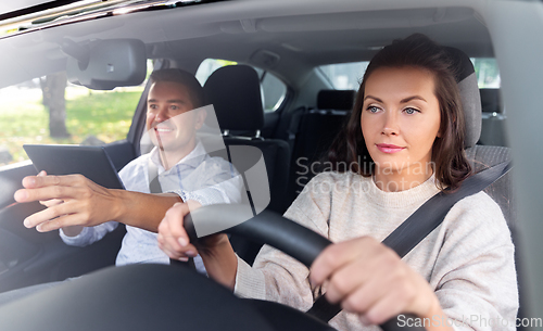 Image of woman and driving school instructor in car