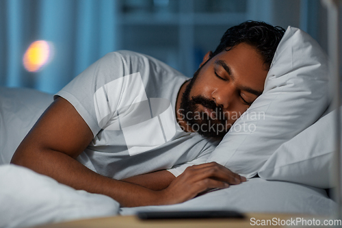 Image of indian man sleeping in bed at home at night