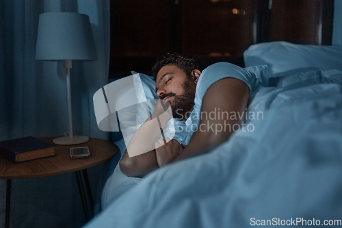 Image of indian man sleeping in bed at home at night