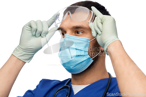 Image of male doctor in goggles, mask and gloves