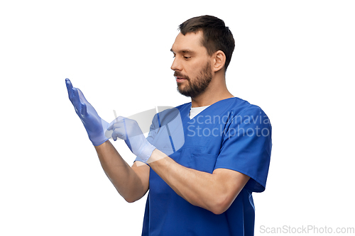 Image of doctor or male nurse putting medical gloves on