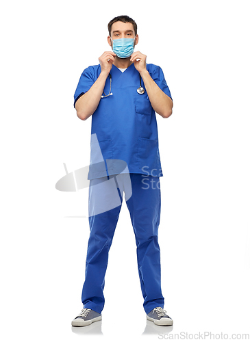 Image of male doctor in blue uniform and mask