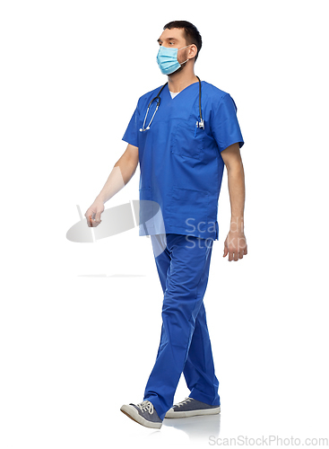 Image of male doctor in blue uniform and mask walking