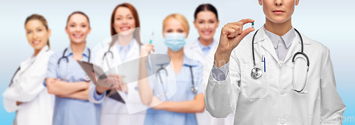 Image of close up of female doctor holding medicine pill