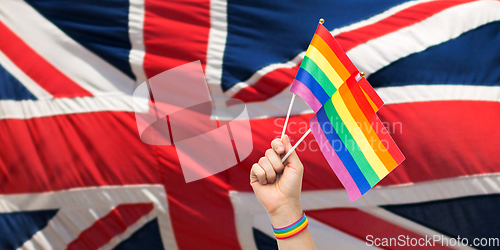 Image of hand with gay pride rainbow flags and wristband