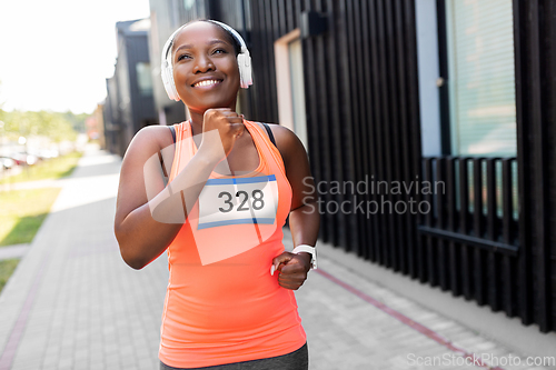 Image of happy african american woman running marathon