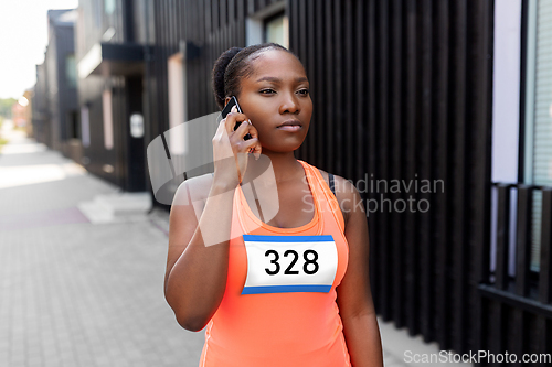 Image of female marathon runner calling on smartphone