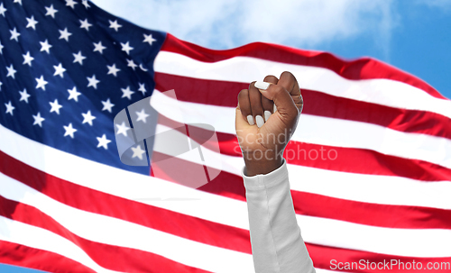 Image of african woman's hand showing fist on american glag