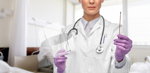 Image of female doctor with cotton swab and test tube