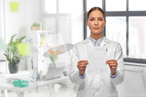 Image of female doctor with prescription blank at hospital