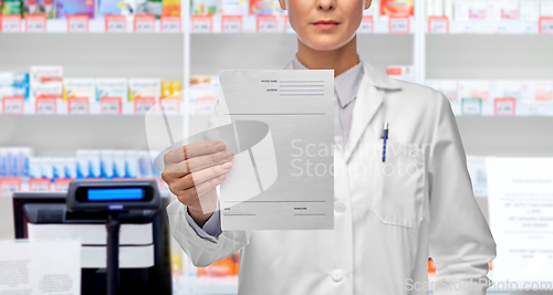 Image of close up of female doctor with prescription blank