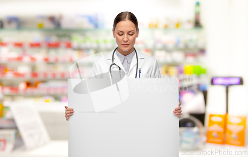 Image of female doctor holding white board at pharmacy