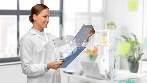 Image of happy female doctor with clipboard at hospital