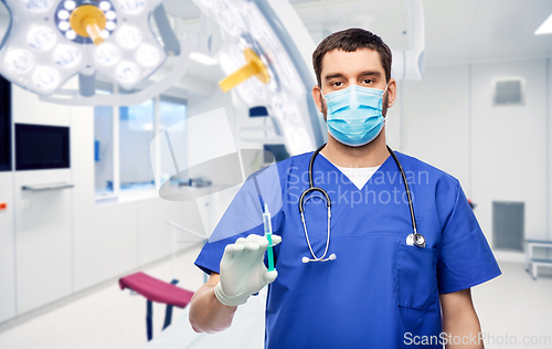 Image of male doctor in mask and gloves with syringe