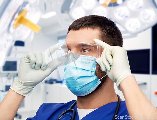 Image of male doctor in goggles, mask and gloves