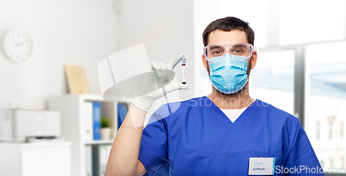 Image of male doctor in mask with blood in test tube