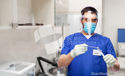 Image of male doctor in mask with cotton swab and test tube