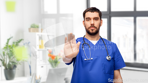 Image of doctor or male nurse showing stop gesture