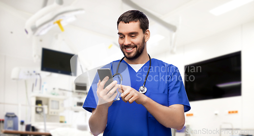 Image of smiling doctor or male nurse using smartphone