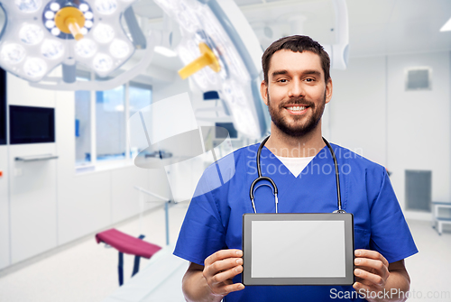 Image of happy doctor or male nurse showing tablet computer