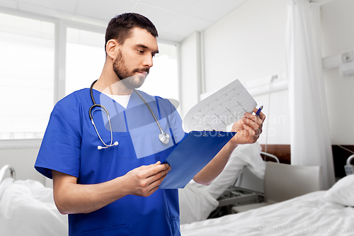 Image of male doctor with cardiogram on clipboard