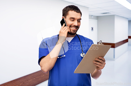 Image of smiling doctor or male nurse calling on smartphone