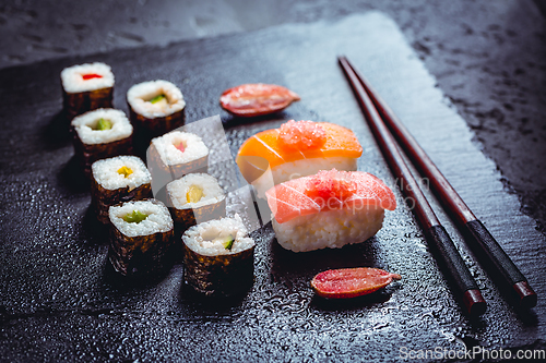 Image of Assortment of vegan sushi with vegetables, seitan, Konjac plant, tofu as fish substitutes, with finger lime as caviar on black