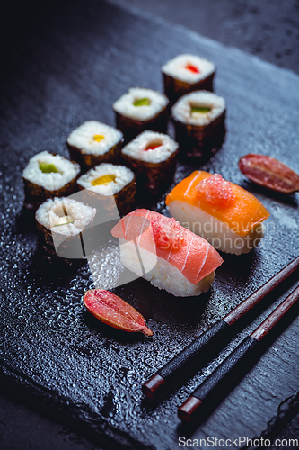 Image of Assortment of vegan sushi with vegetables, seitan, Konjac plant, tofu as fish substitutes, with finger lime as caviar on black