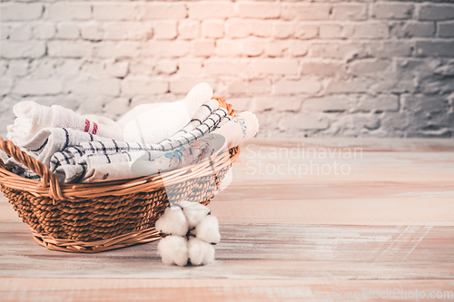 Image of A stack of organic kitchen towels in a basket with cotton flower. Concept of sustainability