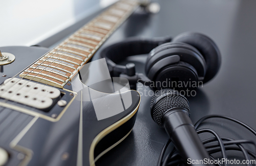 Image of close up of bass guitar, microphone and headphones