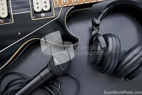 Image of close up of bass guitar, microphone and headphones