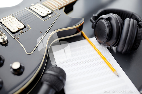 Image of close up of guitar, music book and headphones