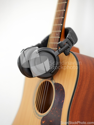 Image of close up of acoustic guitar and headphones