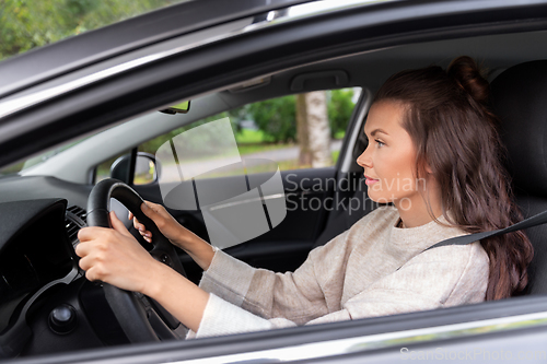 Image of woman or female driver driving car in city