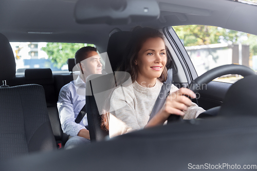 Image of female driver driving car with male passenger