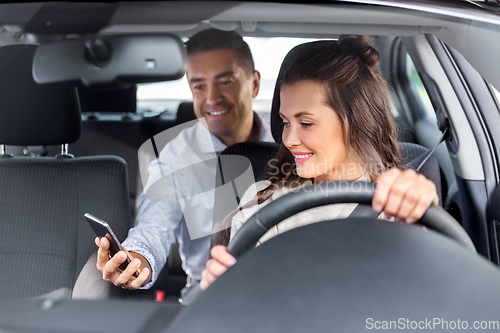 Image of female driver driving car with male passenger