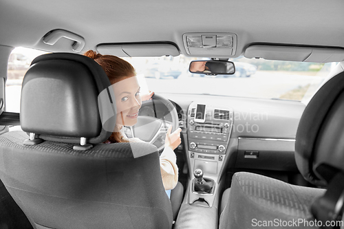 Image of smiling woman or female driver driving car in city